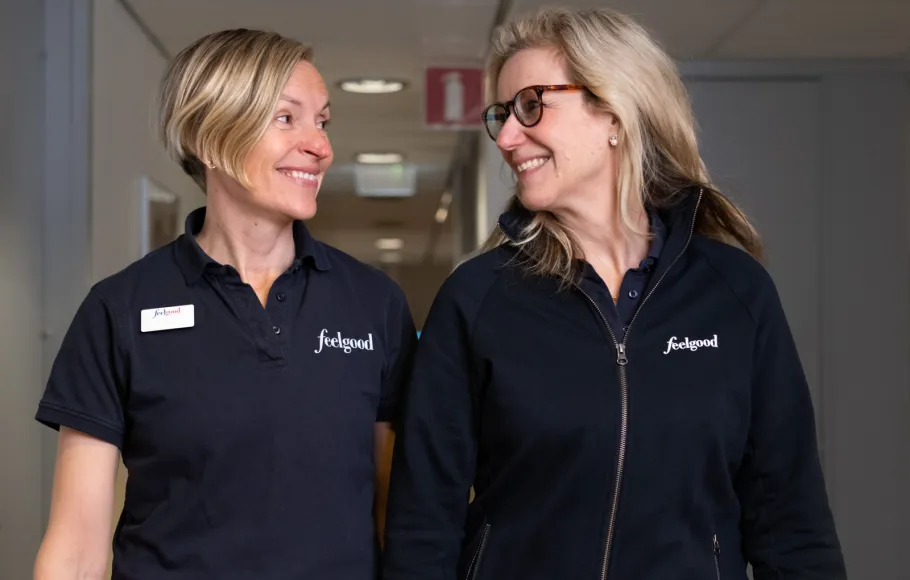 Två kvinnor i Feelgood-kläder går i korridor