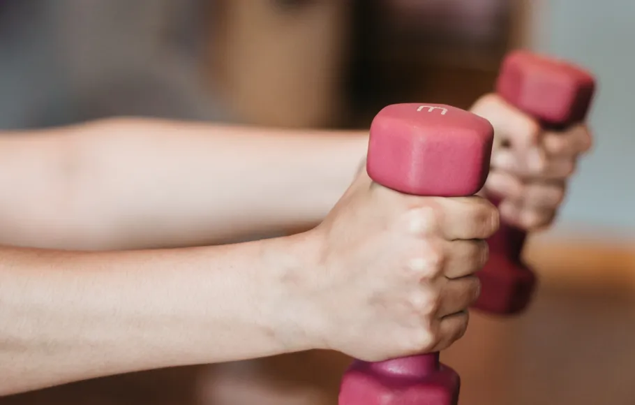 händer som håller i hantlar