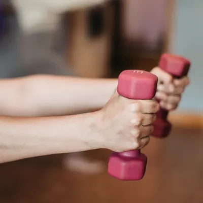 händer som håller i hantlar