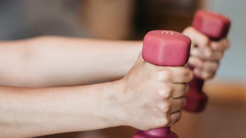 händer som håller i hantlar